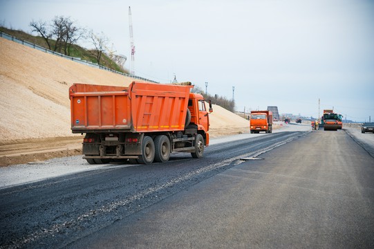 pomarańczowa ciężarówka na budowie nowej drogi
